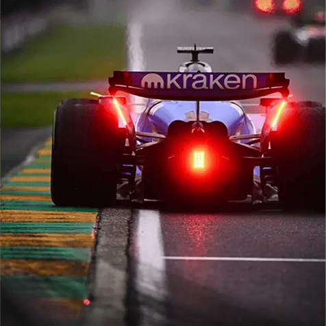 Formula 1 car on a wet track, seen from behind
